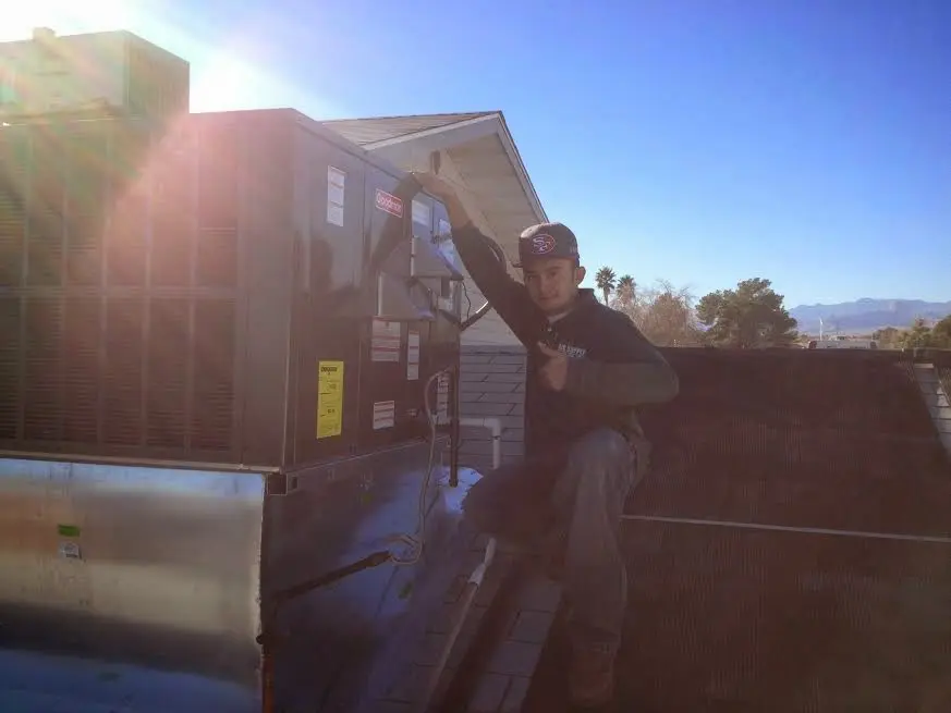 HVAC technician performing Boiler Repair on a rooftop unit in McDonough